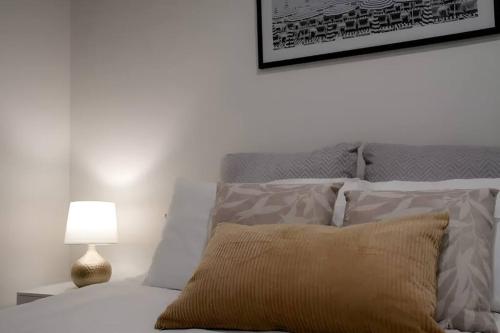 メルボルンにあるMt1012 - 1 BR Docklands Delight, Stunning Apartmentのベッドルーム(枕、ランプ付)