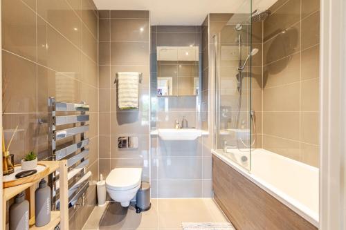 a bathroom with a toilet and a sink and a shower at FMSS - City Luxe in London