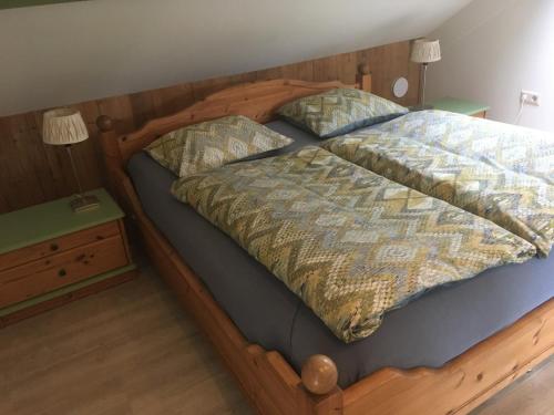 a bedroom with a wooden bed with a wooden frame at Vakantieboerderij 't Zand - Appartement in Heeswijk-Dinther