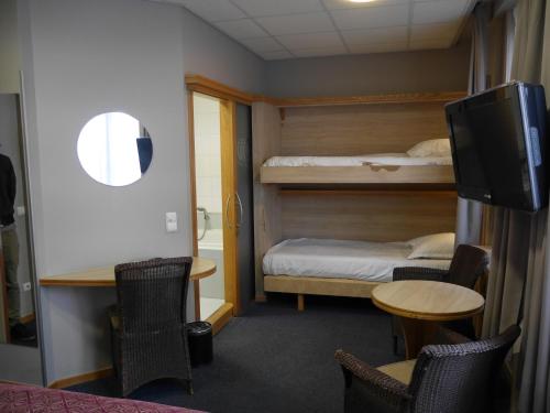 a room with two bunk beds and a table and chairs at Hotel Cajou in De Panne