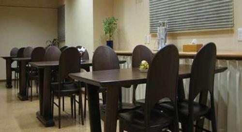 eine Reihe von Tischen und Stühlen in einer Cafeteria in der Unterkunft Business Hotel Prince in Takamatsu