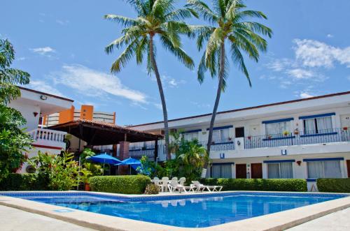 a resort with a swimming pool and palm trees at Hotel Hacienda Vallarta - Playa Las Glorias in Puerto Vallarta