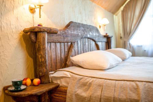 a bedroom with a wooden bed and fruit on a table at Drevny Grad Park-hotel in Lviv