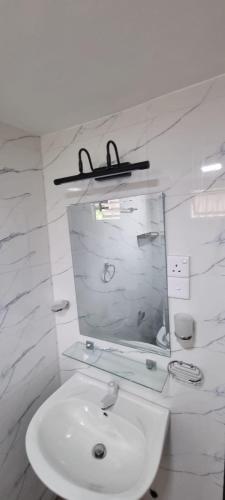 a bathroom with a white sink and a mirror at Yala Reach Hotel in Tissamaharama