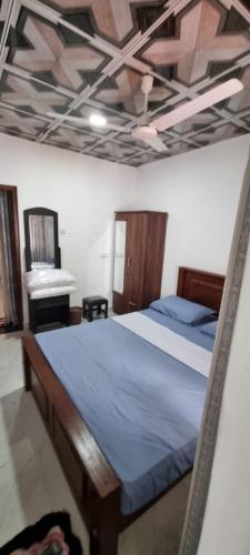 a bedroom with a bed with a blue comforter at Yala Reach Hotel in Tissamaharama