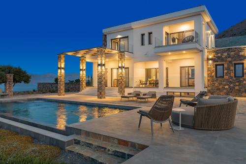 a house with a swimming pool in front of a house at Sole Mare Luxury Villa With Sea View & Private Pool in Elounda in Elounda