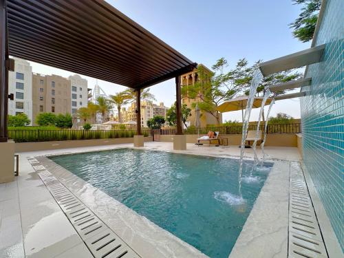 a swimming pool with a water fountain at MegaLuxury Flat Resort, Amazing Pool, Burj direct View in Dubai
