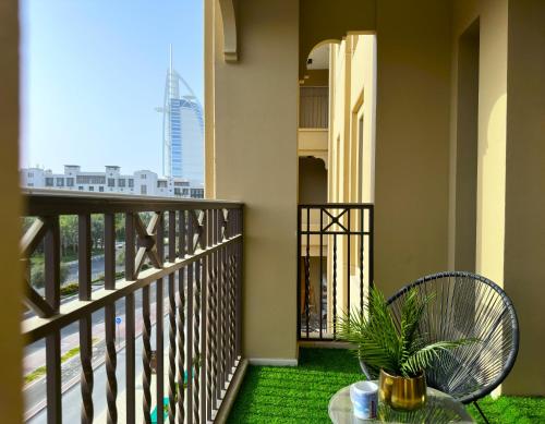a balcony with a table and a plant at MegaLuxury Flat Resort, Amazing Pool, Burj direct View in Dubai