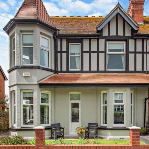 a large black and white house with benches in front at Ty Llwyd - Luxury holiday home sleeping 8, Hot Tub available in Llandudno