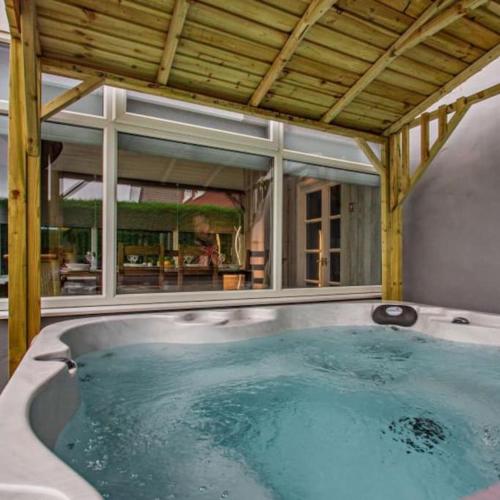 a hot tub in a house with a large window at Ty Llwyd - Luxury holiday home sleeping 8, Hot Tub available in Llandudno