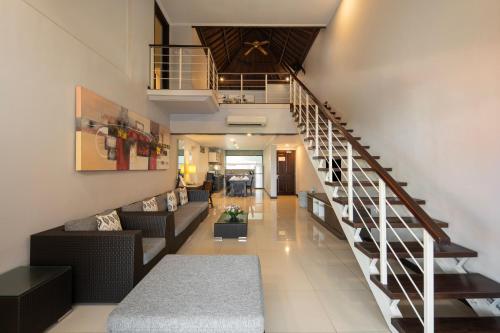 a staircase in a house with a living room at Prime Plaza Suites Sanur – Bali in Sanur