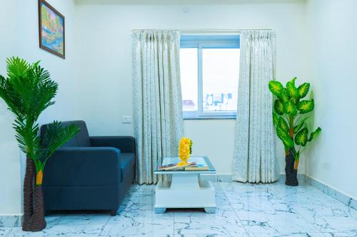 a living room with a blue couch and a window at Hotel Aerotel,Hyderabad in Shamshabad