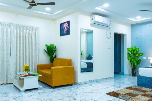 a living room with a yellow chair and a ceiling fan at Hotel Aerotel,Hyderabad in Shamshabad