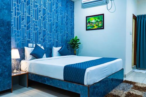 a blue bedroom with a bed and a blue wall at Hotel Aerotel,Hyderabad in Shamshabad