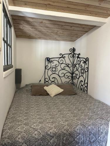 - un lit avec une tête de lit en fer noir dans une chambre dans l'établissement La Dépendance 13D rue Pasteur, à Saint-Mandrier-sur-Mer