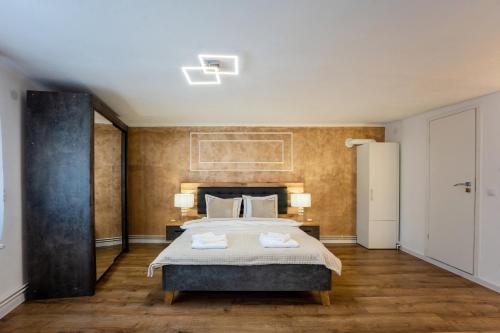 a bedroom with a large bed with two towels on it at Central House by Amelie in Sighişoara
