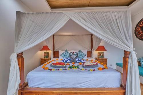 a bedroom with a large bed with white curtains at Unique 1BR Villa for a couple in Ubud in Ubud