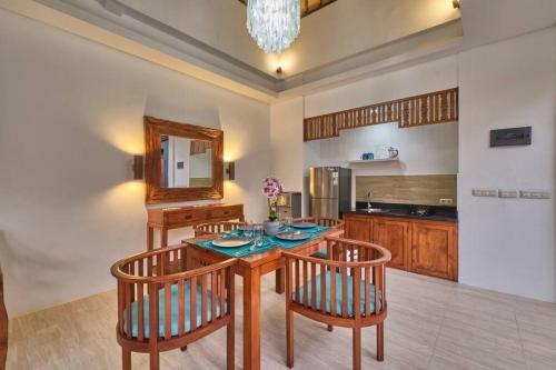 a kitchen with a table with chairs and a mirror at Unique 1BR Villa for a couple in Ubud in Ubud