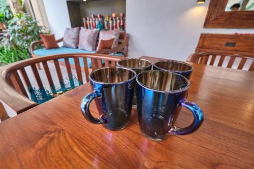 three coffee mugs sitting on top of a wooden table at Unique 1BR Villa for a couple in Ubud in Ubud