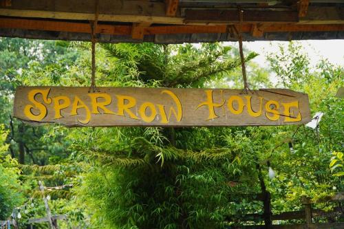 a sign that reads sparrow house hanging from a roof at Sparrow House, Landing Site, 3-bedroom house, Kitchen, Bonfire in Bīr