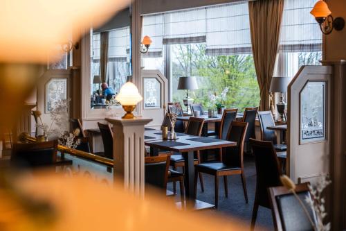 a restaurant with tables and chairs and a large window at Hotel des Nordens Flensburg Wellness & Spa in Flensburg