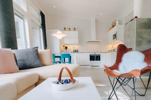 ロヴァニエミにあるVilla Ailoのソファと椅子、キッチンのあるリビングルーム