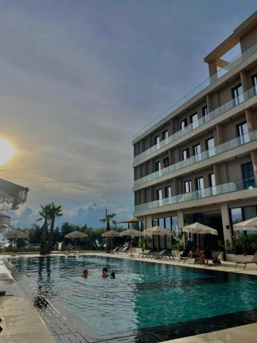 a swimming pool in front of a hotel at Tris3 Hotel in Vlorë