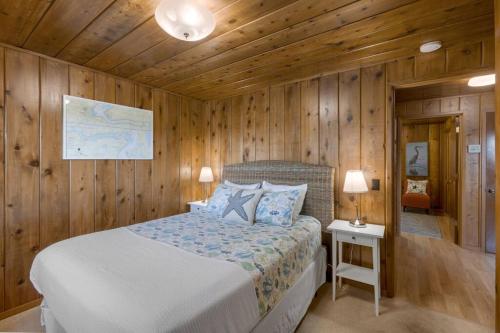 a bedroom with a bed in a wooden wall at Captain's Retreat in Shelton