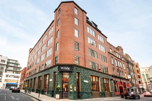 a tall brick building on the corner of a street at Wilde Aparthotels London Liverpool Street in London