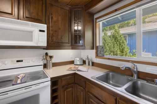 a kitchen with wooden cabinets and a sink and a window at Captain's Retreat in Shelton