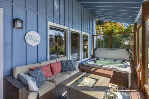 a patio with a couch and a tub on a blue wall at Captain's Retreat in Shelton