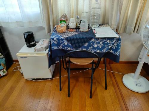 a table with a blue and white table cloth on it at 民泊マエダハウス B&B Maeda House in Aira