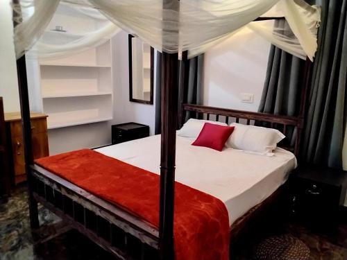a bedroom with a bed with a canopy at Mitra retreats in Mānantoddy
