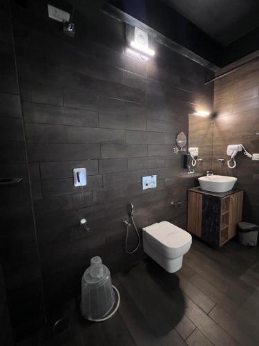 a bathroom with a white toilet and a sink at Roots Munnar in Anachal