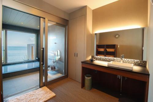 Un baño con lavabo y un espejo grande. en La-se-ri Resort & Stay - Vacation STAY 63346v, en Himi