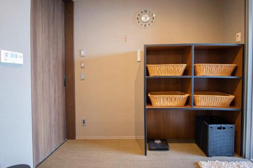 una habitación con estanterías con cestas y un reloj en la pared en La-se-ri Resort & Stay - Vacation STAY 63346v, en Himi