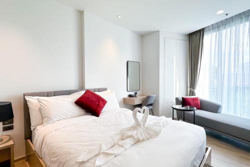 a bedroom with a white bed with red pillows at Central Pattaya Condo With Roof Top Pool in Pattaya Central