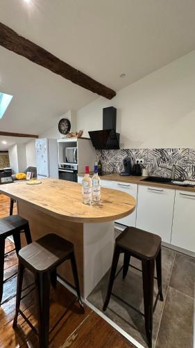 - une cuisine avec une île et 2 bouteilles d'eau dans l'établissement Le Notre-Dame - Au coeur des Chartrons, à Bordeaux