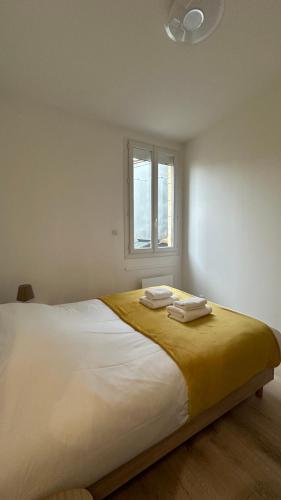 une chambre avec un grand lit avec deux serviettes dessus dans l'établissement Le Notre-Dame - Au coeur des Chartrons, à Bordeaux