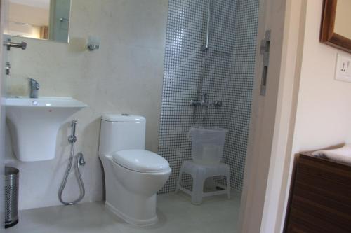 a bathroom with a toilet and a shower and a sink at Two Seas Residence in Ooty