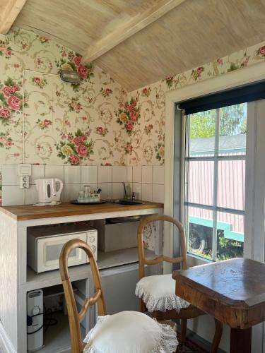 a kitchen with floral wallpaper and a table and chairs at Grand Circus Hotel in Malmö