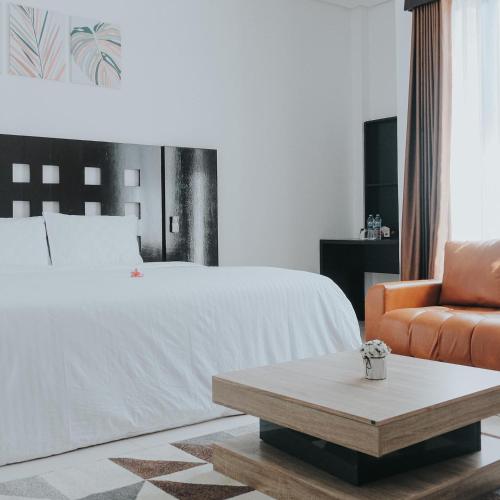 ein Schlafzimmer mit einem Bett, einer Couch und einem Couchtisch in der Unterkunft Hotel Mireya in Saroako
