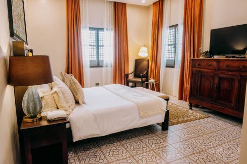 a bedroom with a bed and a dresser and a television at Nawa Wellness in Calatagan