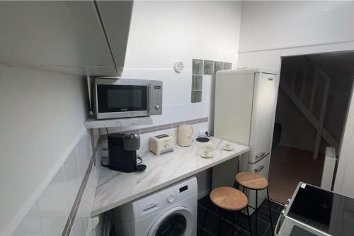 La cuisine est équipée d'un lave-linge, d'un four micro-ondes et d'un réfrigérateur. dans l'établissement Appartement le cocon perché, à Épinay-sur-Seine