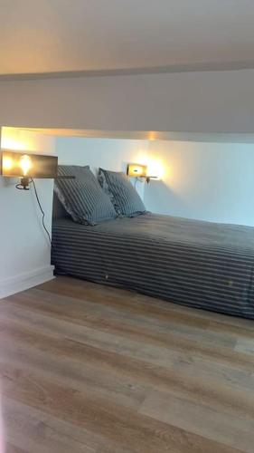 une chambre avec un lit avec deux lampes dessus dans l'établissement Appartement le cocon perché, à Épinay-sur-Seine