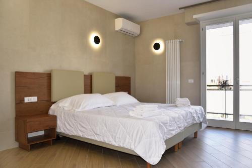a bedroom with a large bed with white sheets at La Maison Latina Guest House in Latina