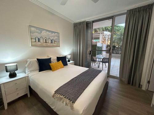 a bedroom with a large bed and a balcony at Redvue Holiday Apartments in Redcliffe