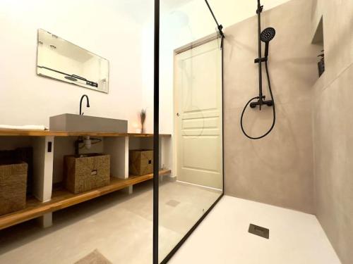 une salle de bain avec une douche avec une porte vitrée dans l'établissement Mas Provençal Privé avec Piscine sans vis à vis en plein Cœur du Luberon, à La Motte-dʼAigues