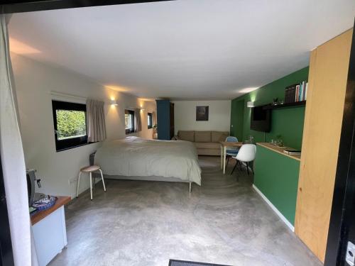 a bedroom with a bed and a living room at La Grange 28 in Bergen op Zoom