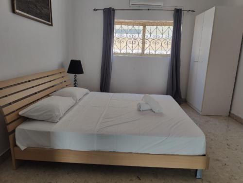a bedroom with a large white bed with a window at Location, Location, Location in St. Julianʼs